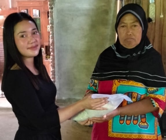 Maya (anak mantu kepala Desa Rejomulyo) saat memberikan Zakat ke pada Marinten (berkerudung) ( foto:dok)