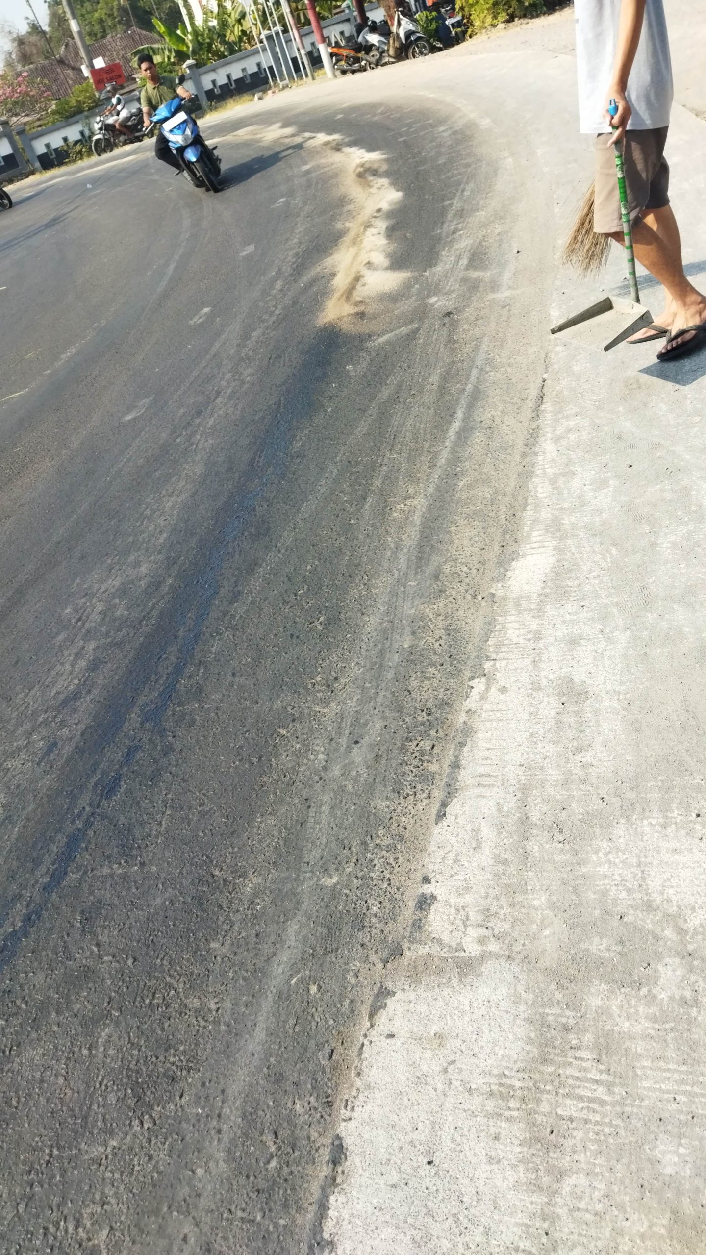 TUMPAHAN SOLAR DI JALAN RAYA, PENGENDARA MOTOR TERJATUH, WARGA JAMBANGAN BERGERAK CEPAT