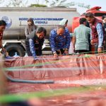 Wabup Ngawi , Dwi Riyanto Jakmiko (berrompi hitam) saat membagikan air bersih (foto: diskominfo)