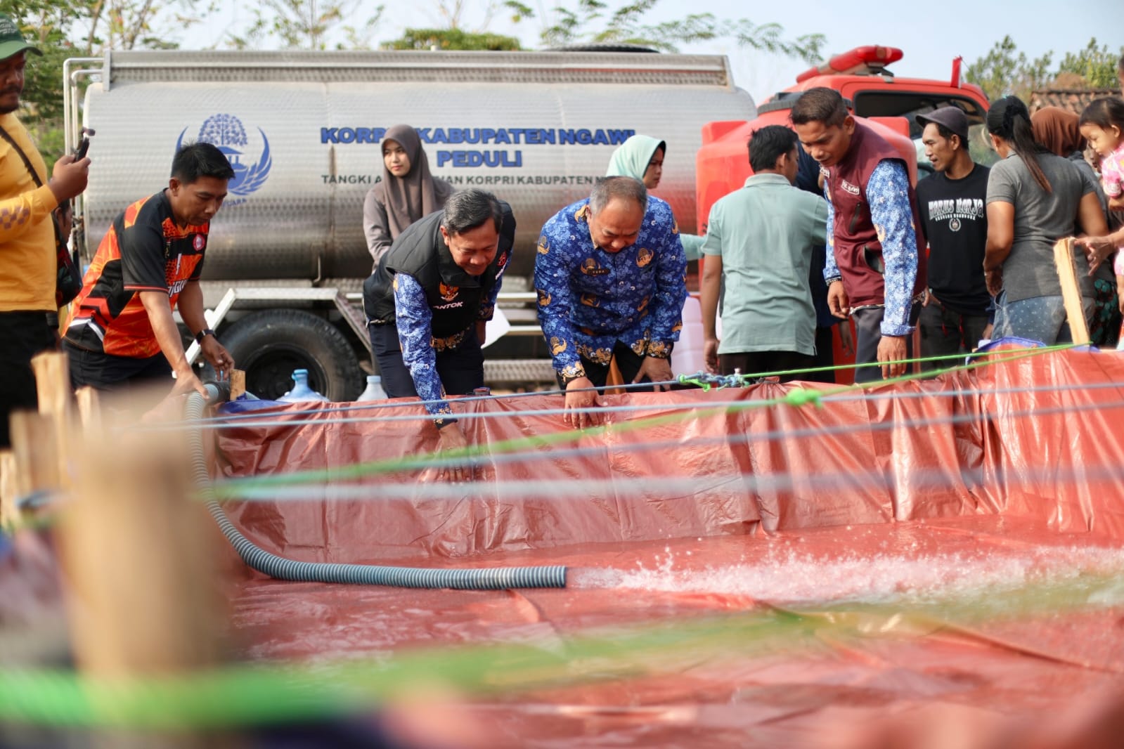 Wabup Ngawi , Dwi Riyanto Jakmiko (berrompi hitam) saat membagikan air bersih (foto: diskominfo)
